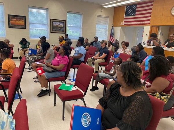 A large group of people sit in chairs.