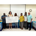 A group of six people posing with an oversized check.