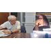 A man and a woman sitting at a table inside doing paperwork.