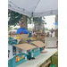 Three people standing at a table with boxes of chips and brown bag lunches.