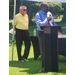 Two men outside with one behind a podium