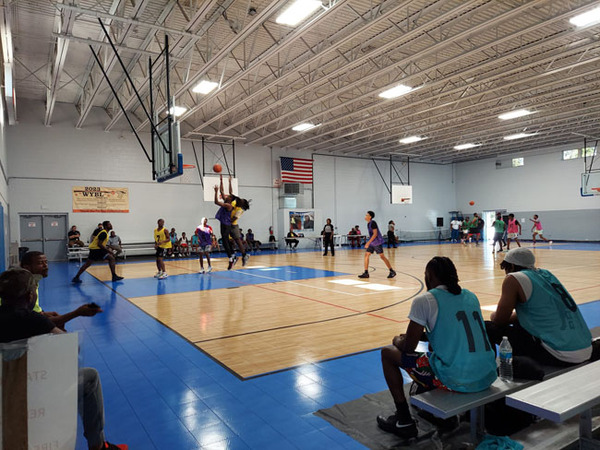 A group of people playing basketball on a court.