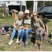  Three people seated in the community garden. 