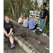  People standing and seated in the community garden. 