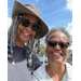  Two ladies in sunglasses smiling on a sunny day. 