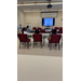  Three students sit at a table looking at a screen on the wall that says Youth Boater Education Course. 1. USCG History. 2. Sea Scouts 3. Safety 4. Know Your Boat 5. Navigation Workshop. 