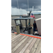  A United States Coast Guard Member drives a boat up to the dock. 