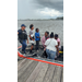  A United States Coast Guard man talks to five people on the boat. 