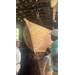  People being shown a big wooden boat. 
