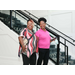  Two women get their picture taken in front of a staircase. 