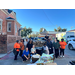  A group of people gather around a truck that is full of bags of food that will be distributed. 