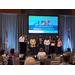 Nine people stand on the stage in front of a screen that says 2025 NC Affordable Housing Conference. 