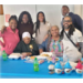  Six people huddle around Lillian Boyd and smile for a picture. 