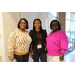  Three women stand and smile for a picture. 
