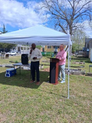 Two people speaking under a tent.