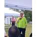  A woman in a green shirt, with a man in the background. 