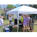  People standing and talking under a tent. 