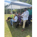  People sitting under the tent in the shade. 