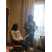  A woman stands and presents while another woman is sitting. 