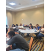  Staff sits at tables and listens. 