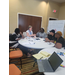  Team members talk at a table. 