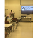  A speaker stands at the front of a room. 