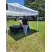  A man check out a table under a tent. 