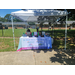  Two people sitting at a table under a tent. 