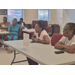  Women listen at tables. 