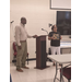  A woman stands next to a man at the front of a room. 