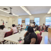  A room full of people listen to someone speak. 