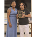  A woman poses next to another woman holding a plaque. 