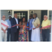  Seven people standing on a porch holding a big ribbon. 