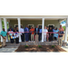 Twenty two people stand on a porch and smile for a picture. 
