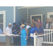  A large group of people standing and cutting the ribbon. 
