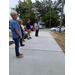  People stand on the sidewalk. 