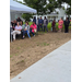  People stand sit under a tent and stand under a tree. 