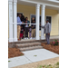  A group of people standing behind a ribbon tied to a house. 