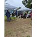  A wide shot of people sitting under two tents. 