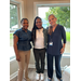  Three women smile for a photo. 